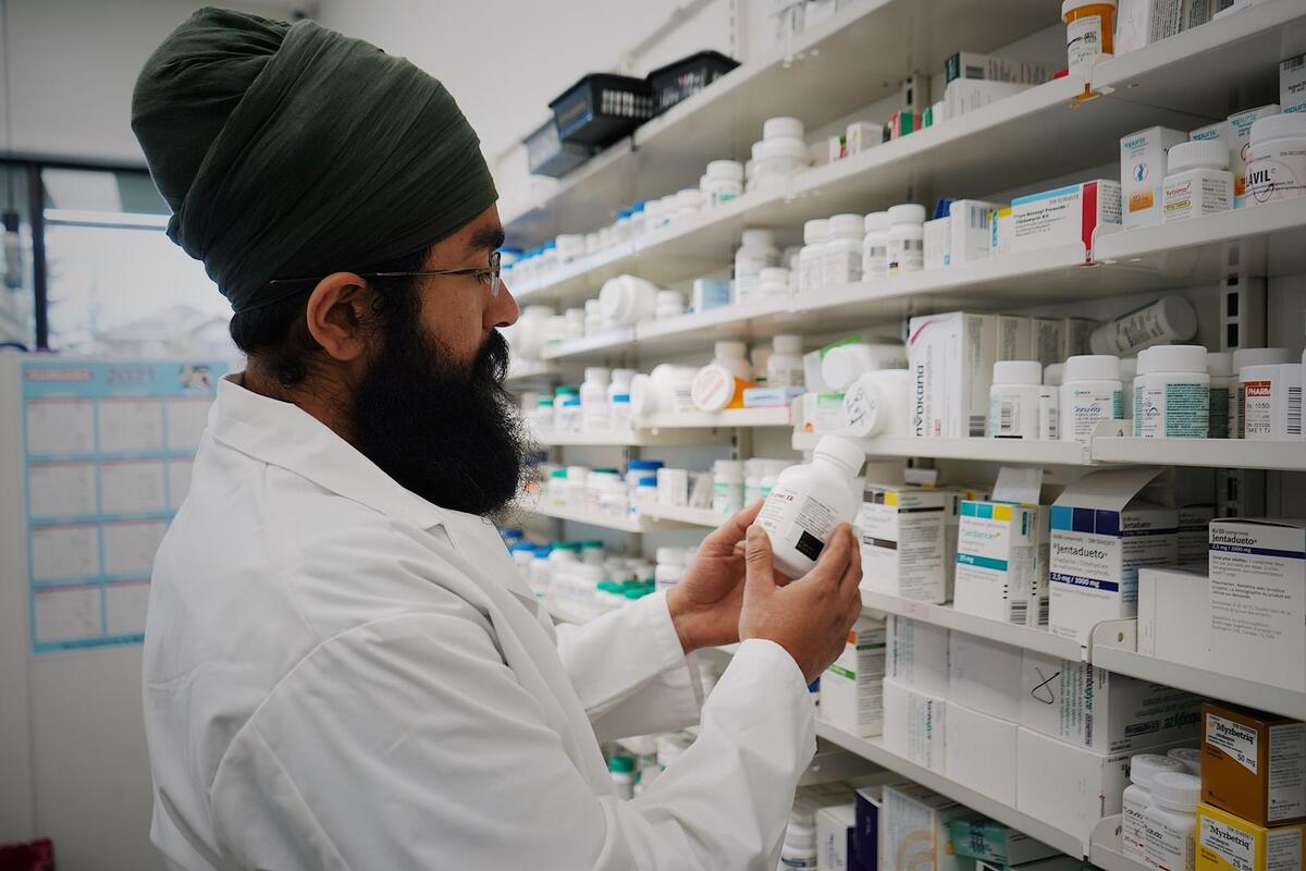 Farmacêutico organizando medicamentos nas prateleiras de uma farmácia