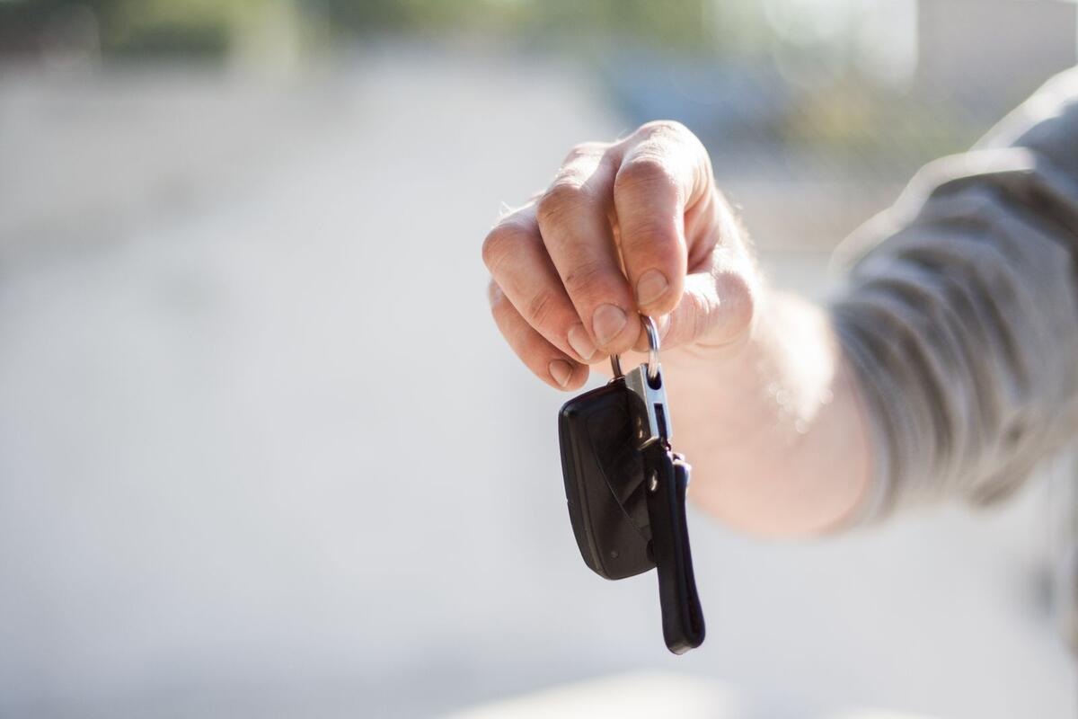 Se o dinheiro não dá para tudo Mão entregando a chave de um carro