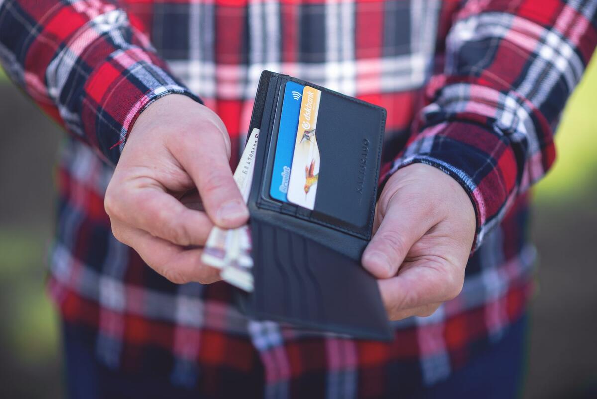 Como reclamar e recuperar o limite Mãos segurando uma carteira aberta com cartões de crédito