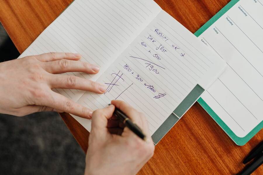 Caderno de contas com receitas e despesas de um pequeno negócio