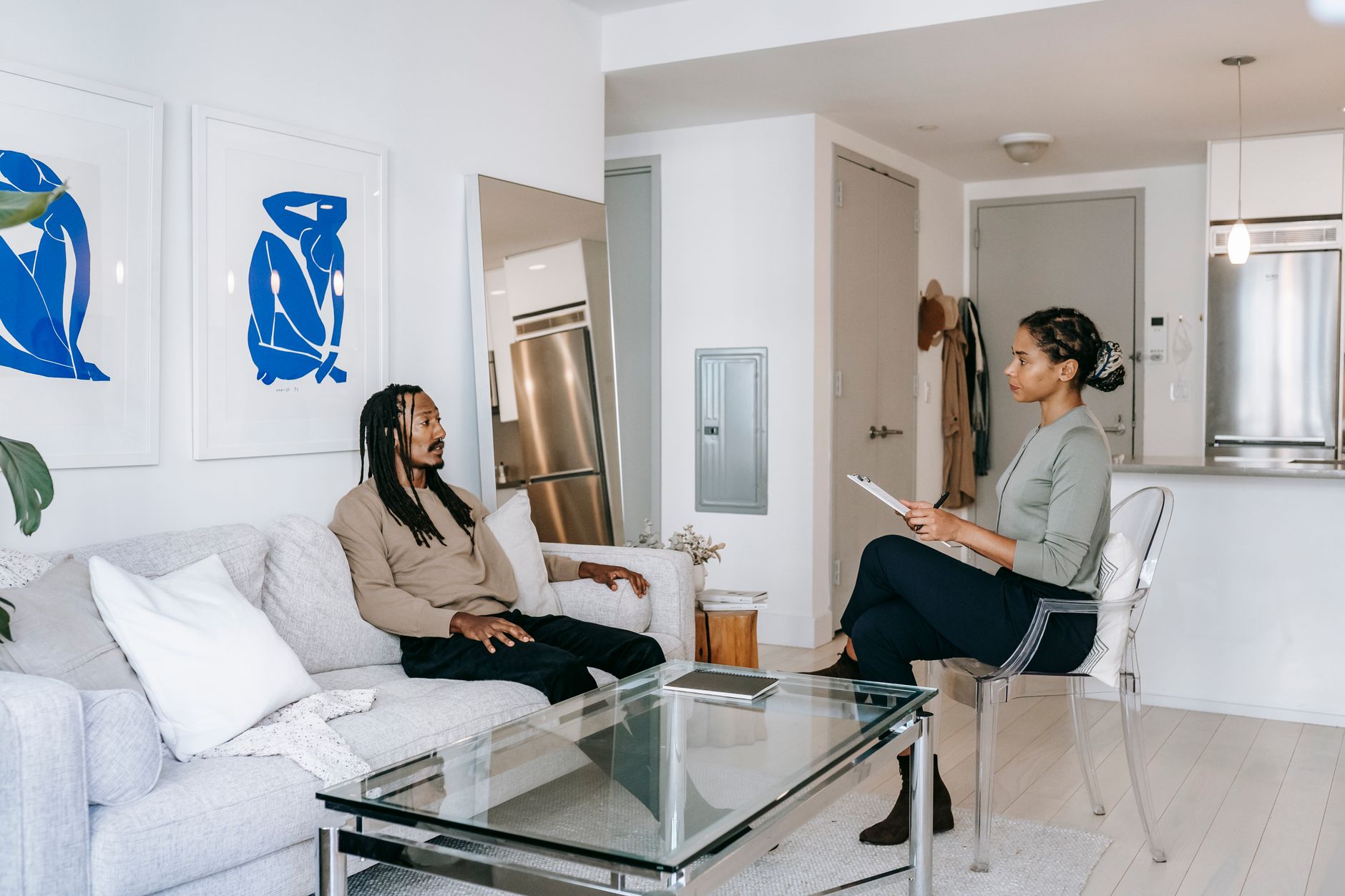 Mutirão de renegociação de dívidas: como participar Concerned African American male in smart casual clothes sitting on comfortable sofa and sharing problems with empathetic female consultant in contemporary psychotherapy center