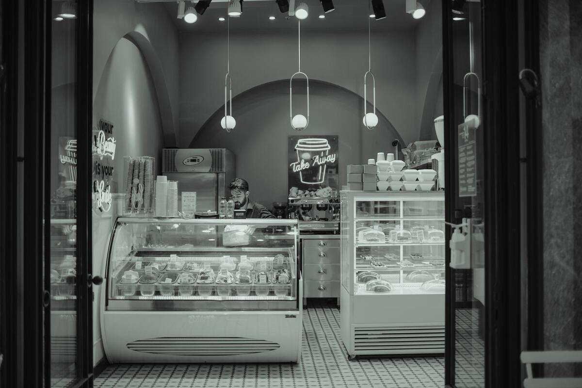 Vale a pena abrir o MEI agora ou limpar o nome antes? Interior de uma confeitaria com vitrine de doces e balcão