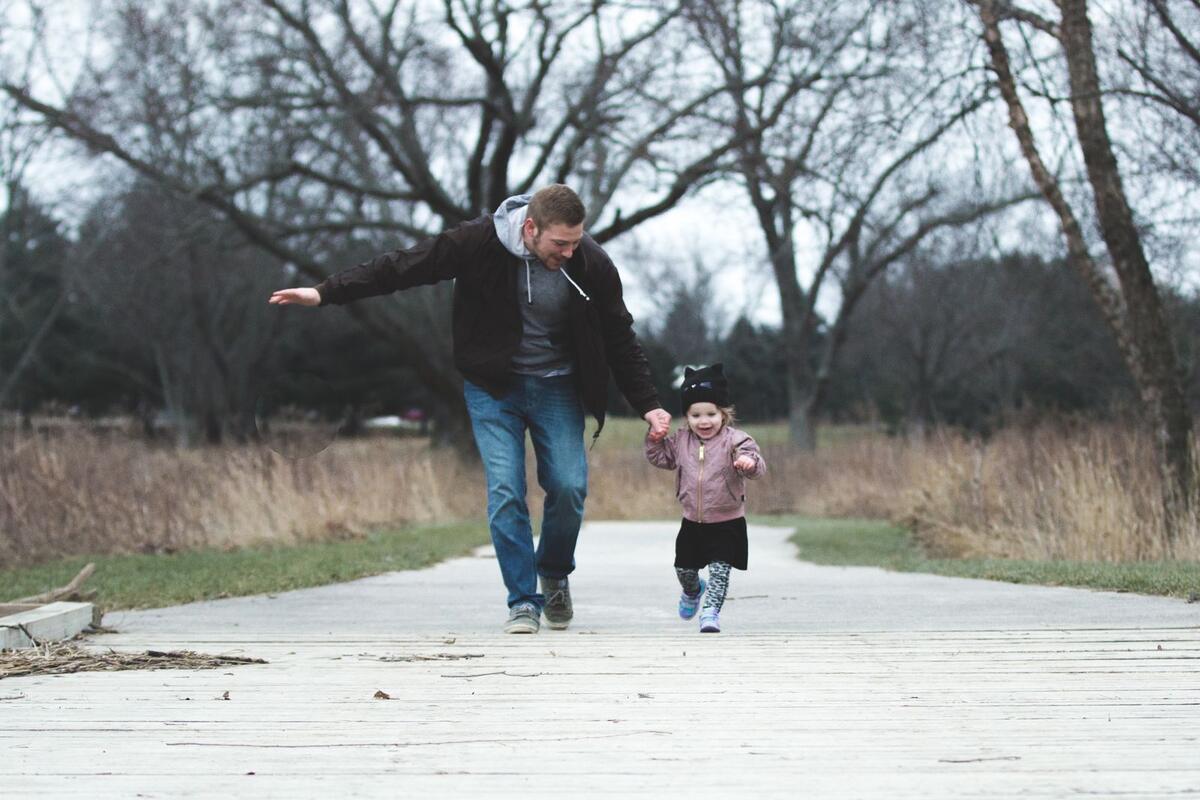 Pai e filha caminhando juntos no parque