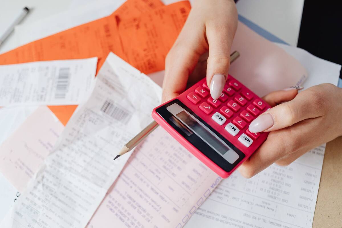 Mãos usando calculadora para controlar despesas e recibos