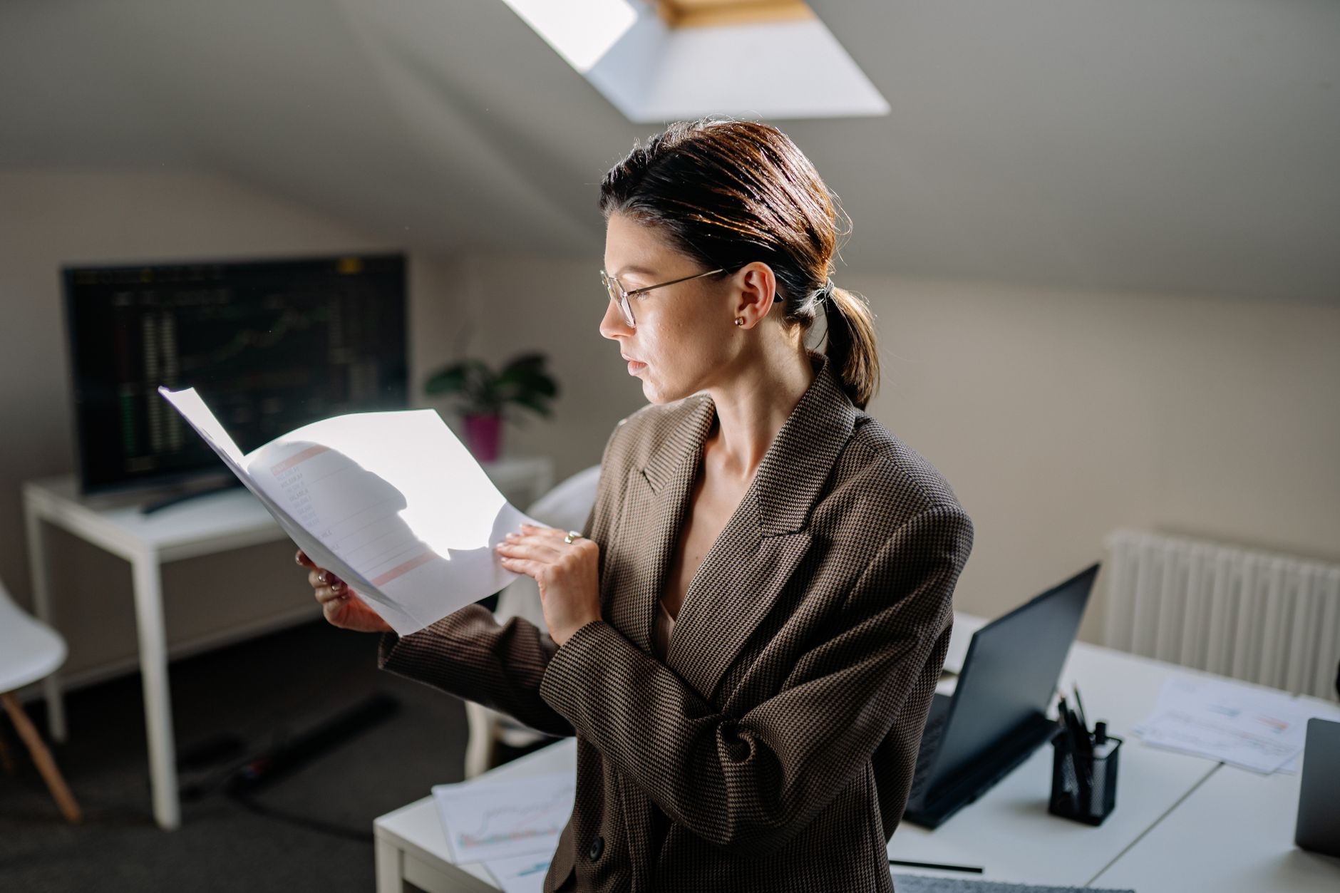 Quanto dá para pegar de empréstimo estando negativado Professional woman in glasses reviewing financial documents at her office desk.