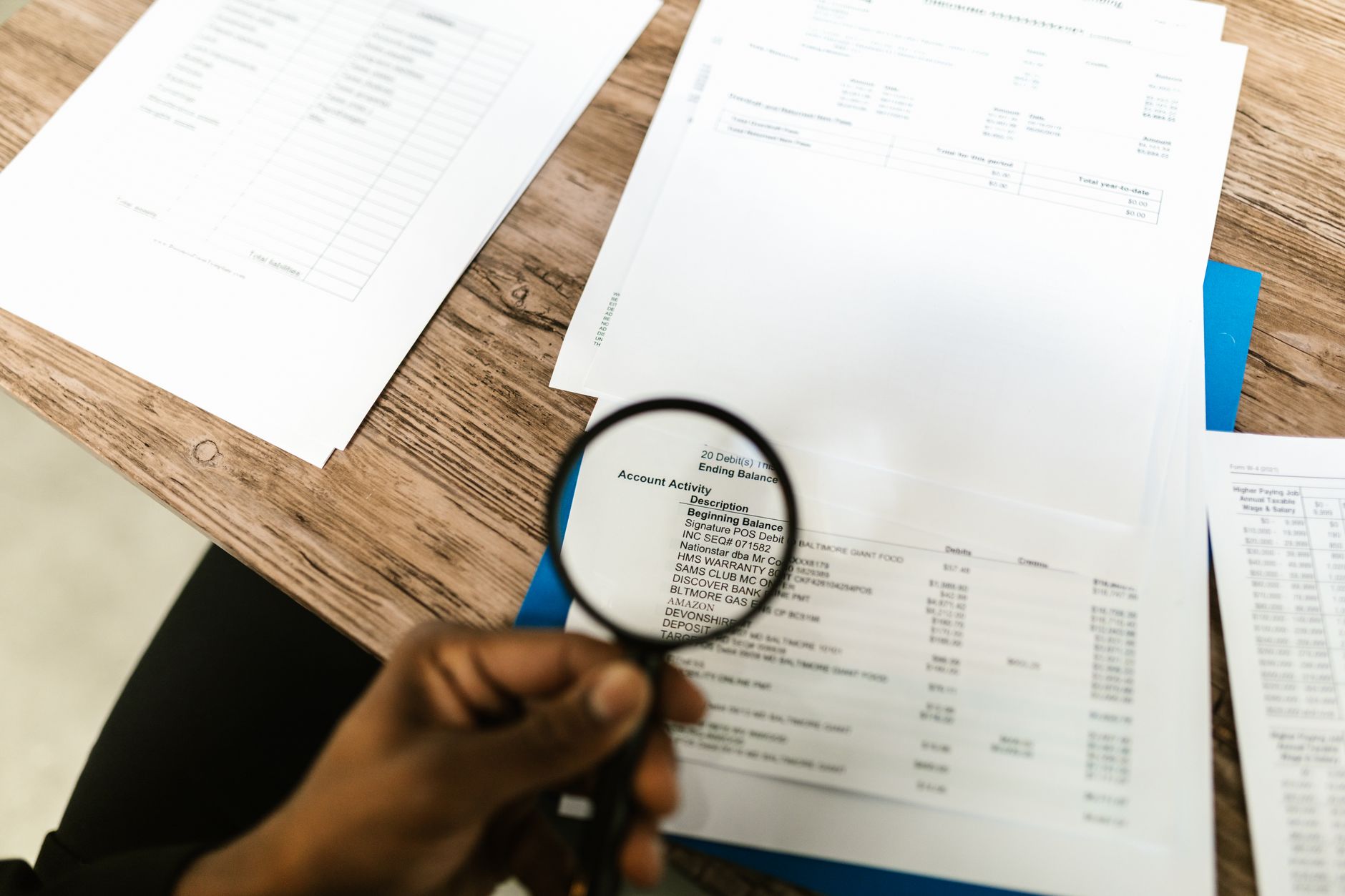 Pessoa analisando um contrato de empréstimo e contas sobre a mesa