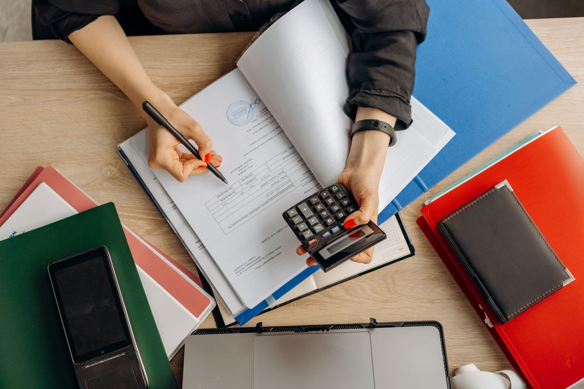 Pessoa analisando uma proposta de empréstimo com calculadora e documentos sobre a mesa