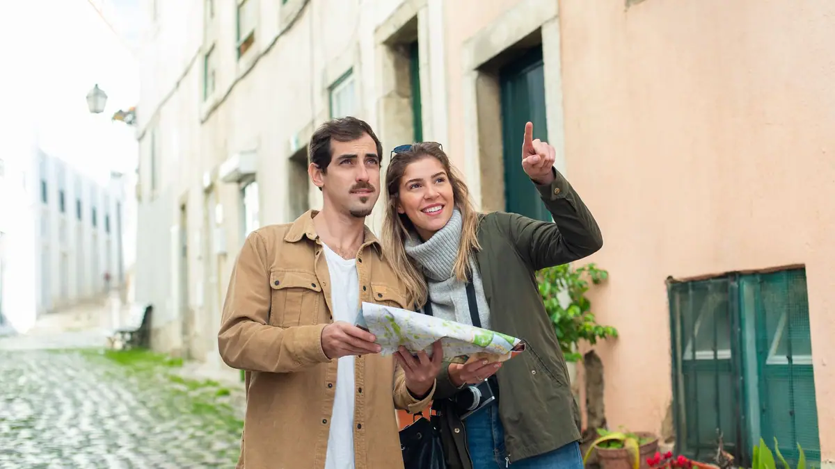 Casal explorando uma cidade histórica europeia com um mapa nas mãos