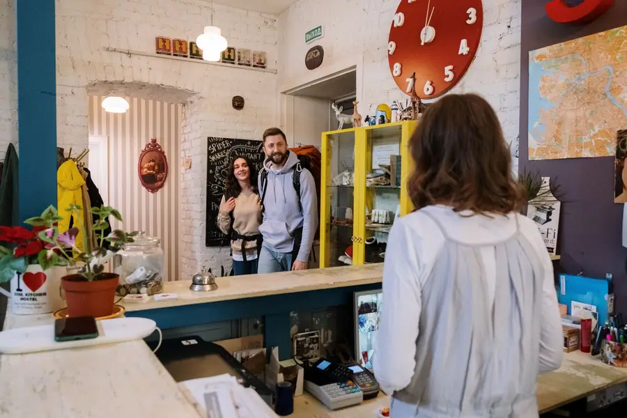 Recepção de um hostel com viajantes fazendo o check-in