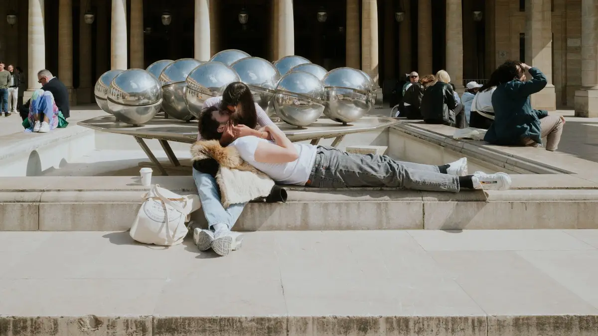 Casal se beijando diante do Palais Royal, em Paris