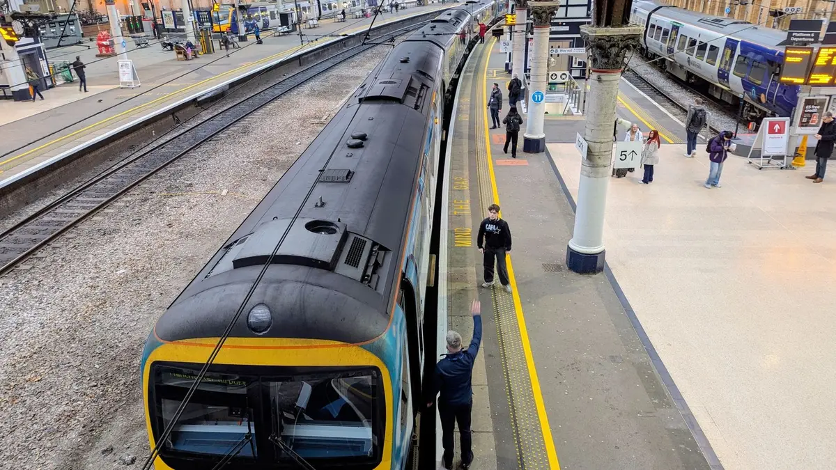 Trem chegando à plataforma de uma estação ferroviária
