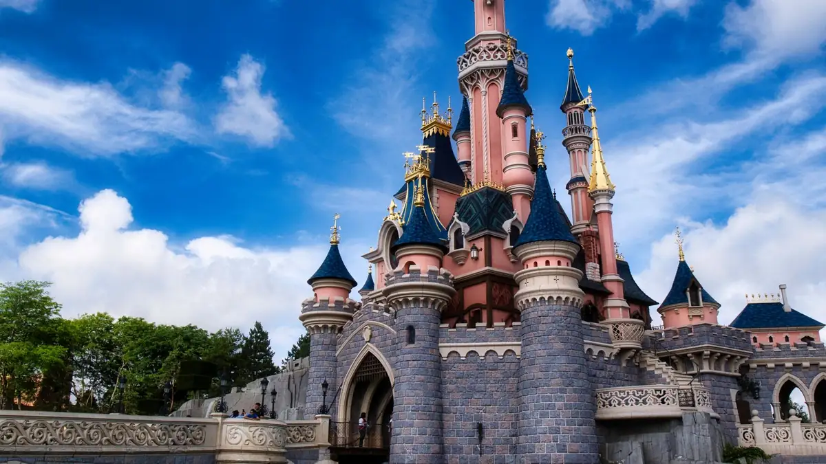 Castelo icônico da Disneyland Paris sob um céu azul