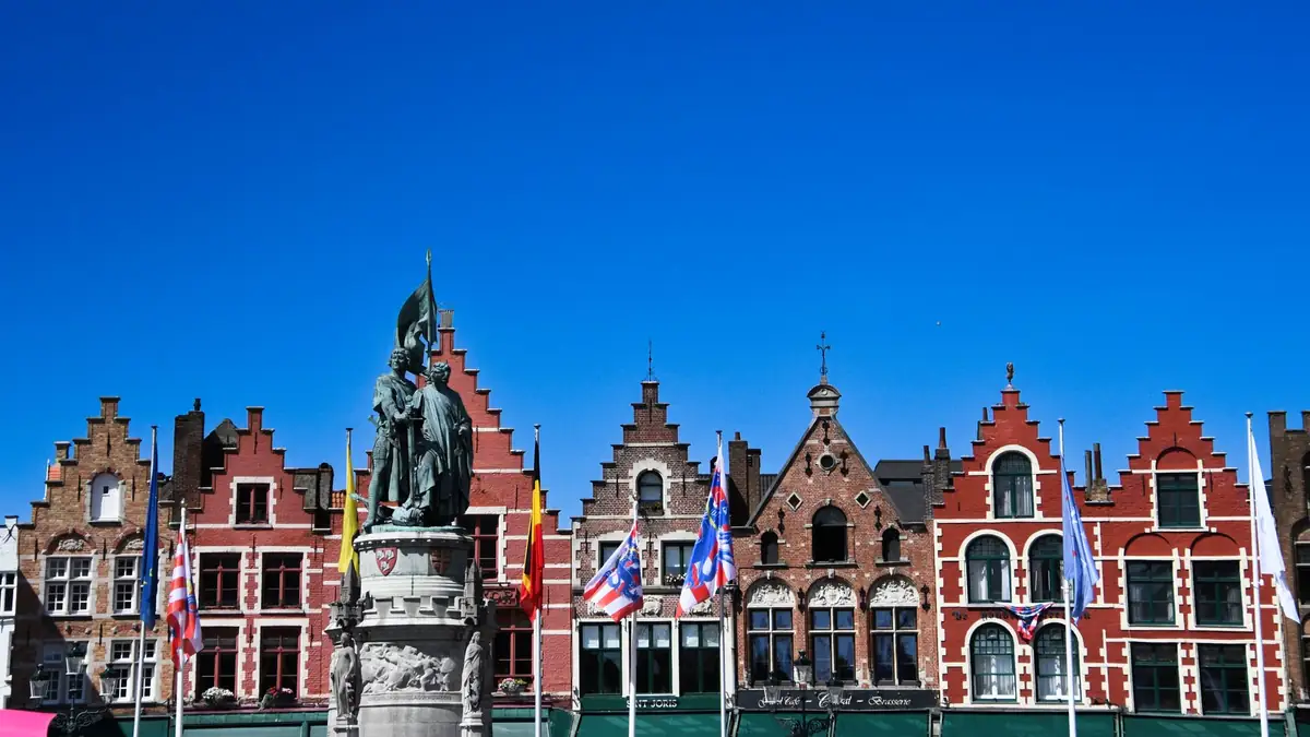 Prédios coloridos da praça do mercado de Bruges sob céu azul