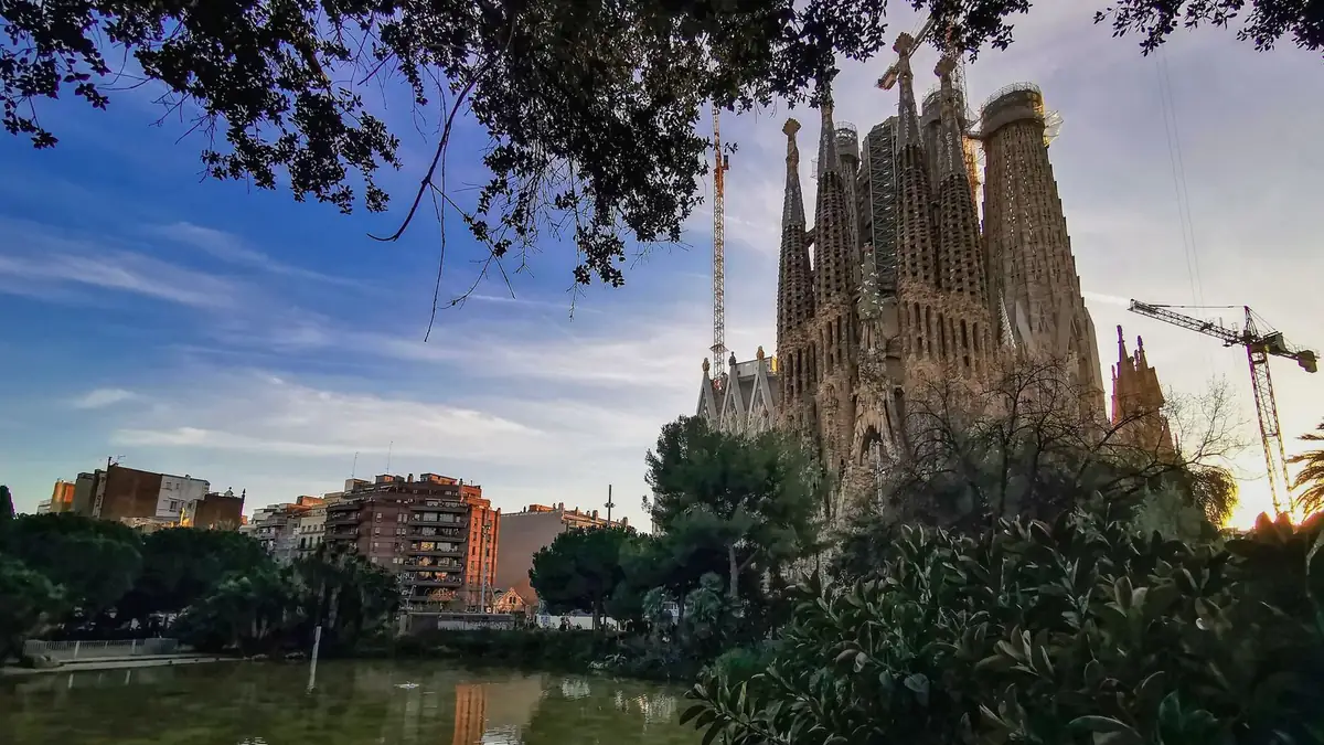 Basílica da Sagrada Família em Barcelona ao entardecer, refletida em um lago
