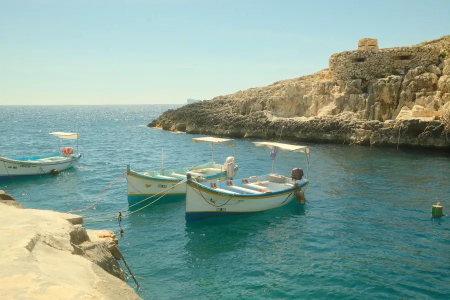 Barcos tradicionais malteses ancorados em águas azuis