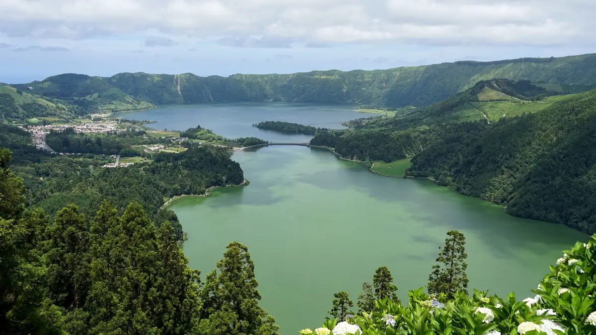 Lagoa vulcânica verde cercada de montanhas na ilha de São Miguel, nos Açores