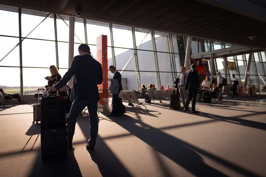 Viajantes com bagagem de mão em um terminal de aeroporto Viajantes com bagagem de mão em um terminal de aeroporto
