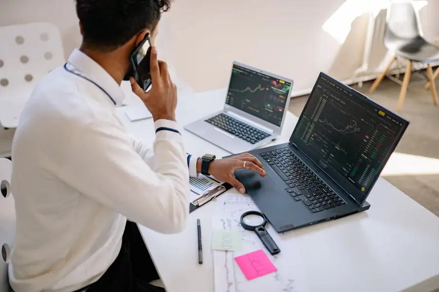 Pessoa analisando gráficos de investimentos em um notebook