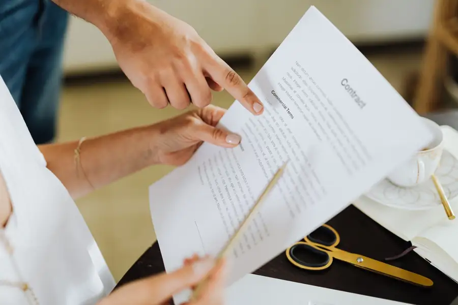 Duas pessoas discutindo um contrato em uma mesa de escritório