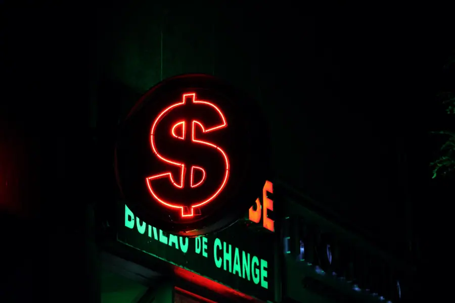 Letreiro neon vermelho com o símbolo do dólar em uma casa de câmbio