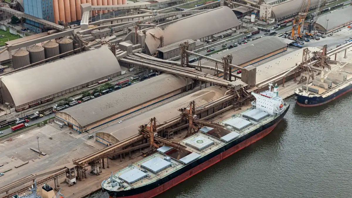 Porto movimentado com navios cargueiros e armazéns