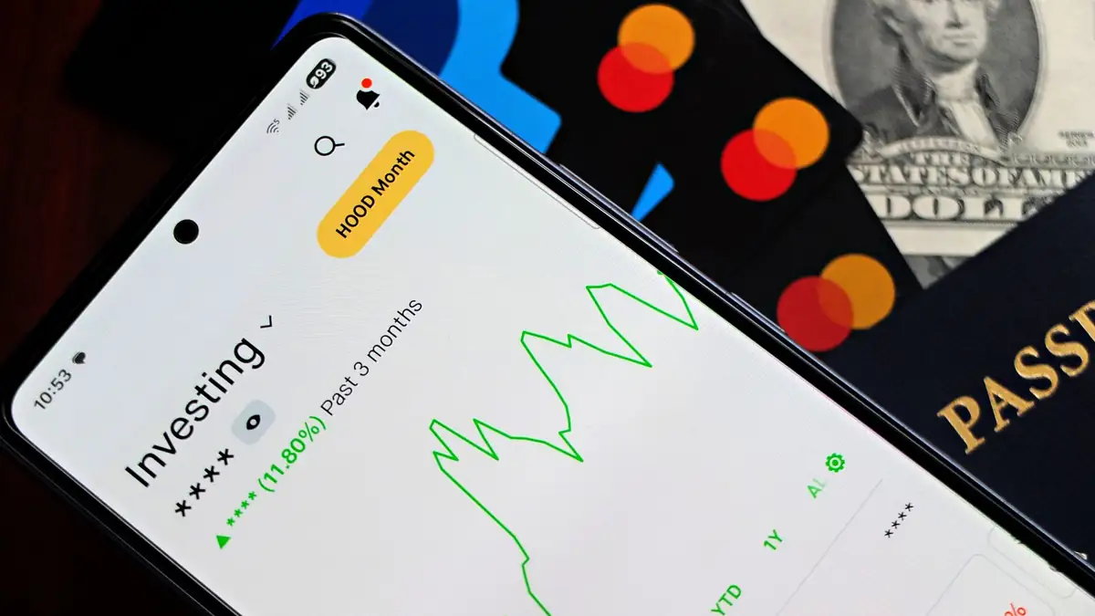 Aplicativo de investimentos com gráficos de crescimento ao lado de cartões e dólares