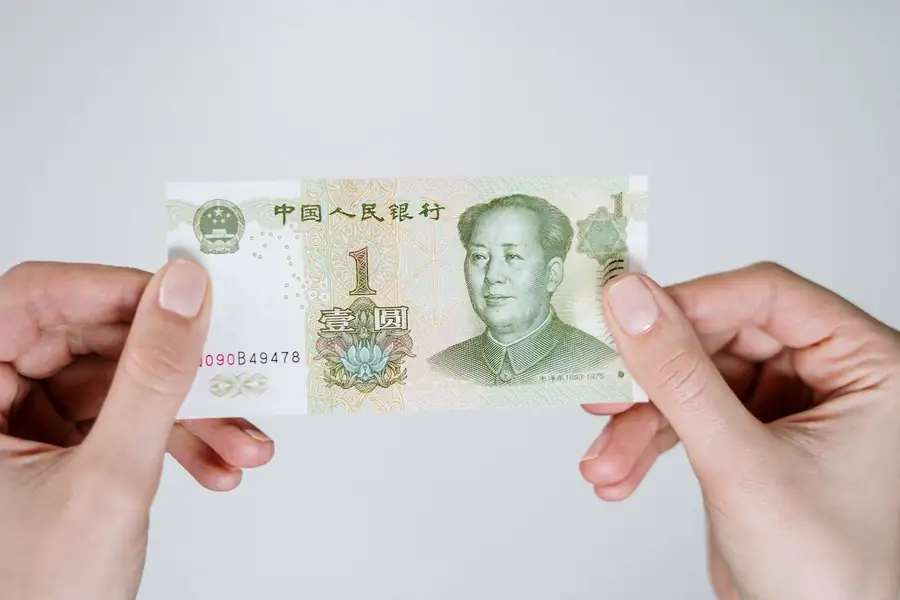 Mão segurando uma nota de um yuan chinês