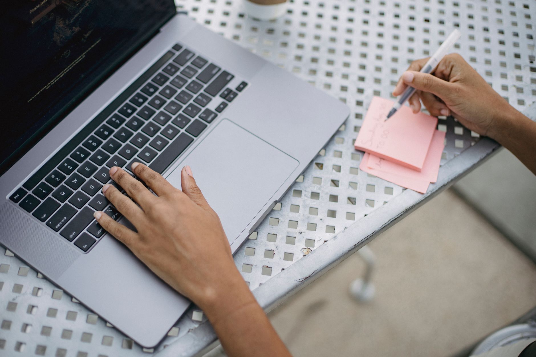 Freelancer trabalhando no laptop enquanto organiza contatos de clientes em um escritório doméstico