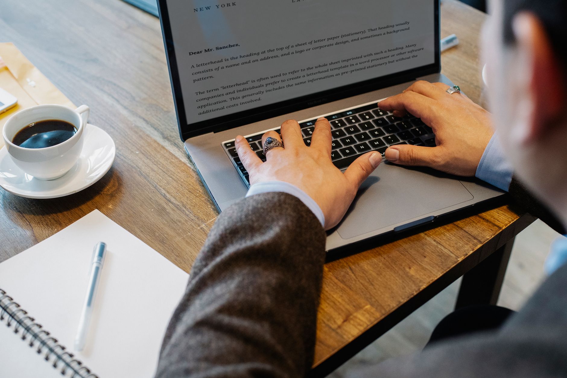 Profissional trabalhando em laptop enquanto lê uma comunicação sobre retorno ao escritório