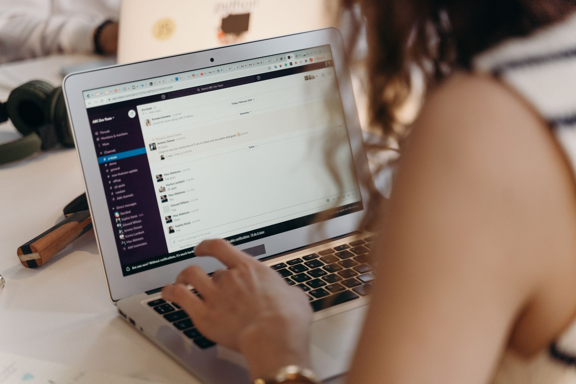 Equipe trabalhando remotamente diante de um painel de tarefas em laptops