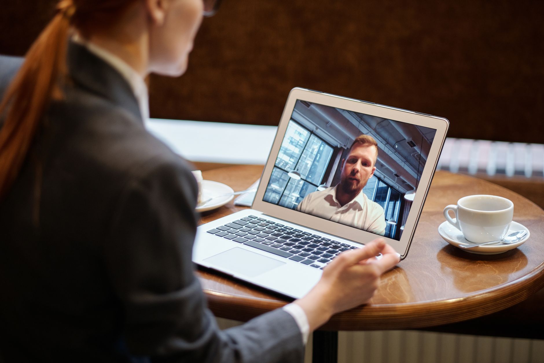 Profissional trabalhando em casa enquanto participa de uma conversa virtual com colegas