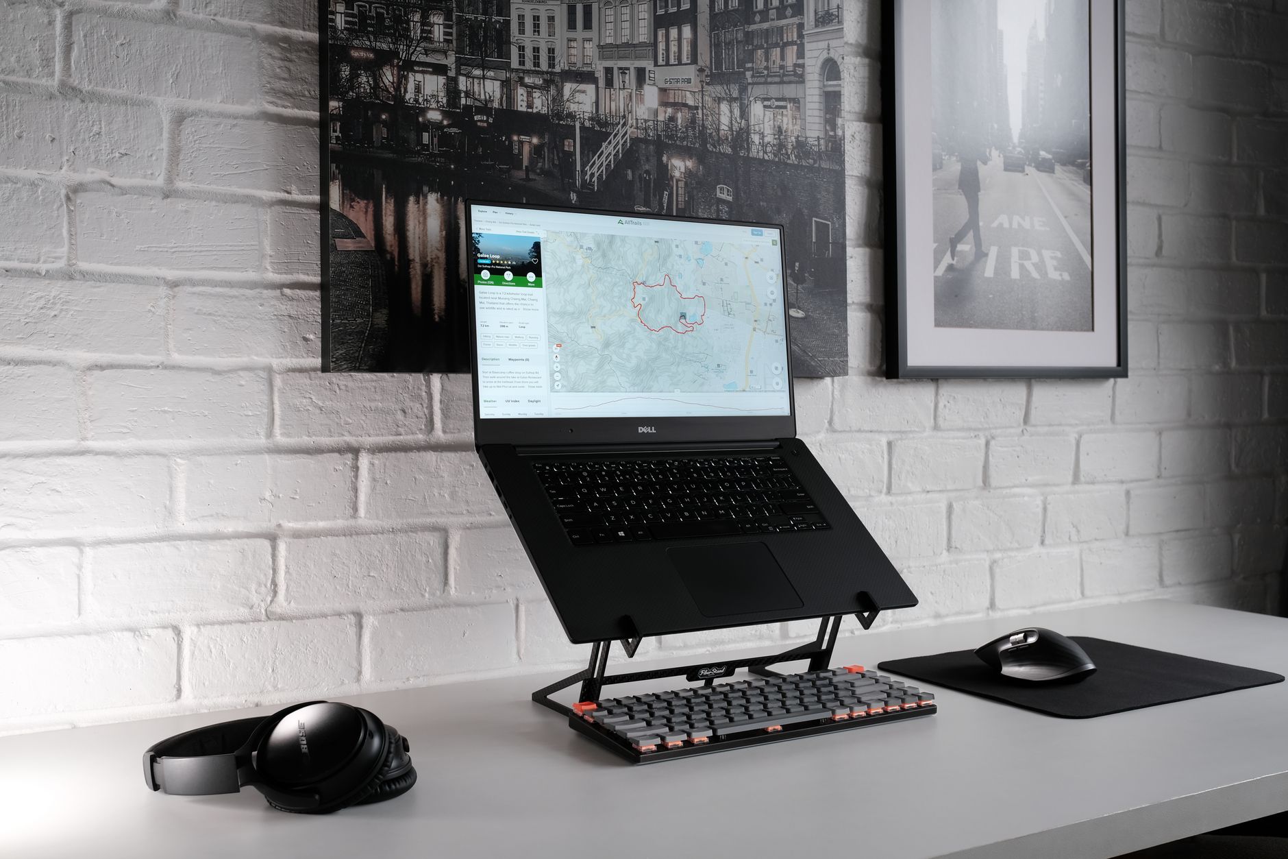 Pessoa trabalhando em mesa de home office organizada com monitor amplo conectado ao notebook.