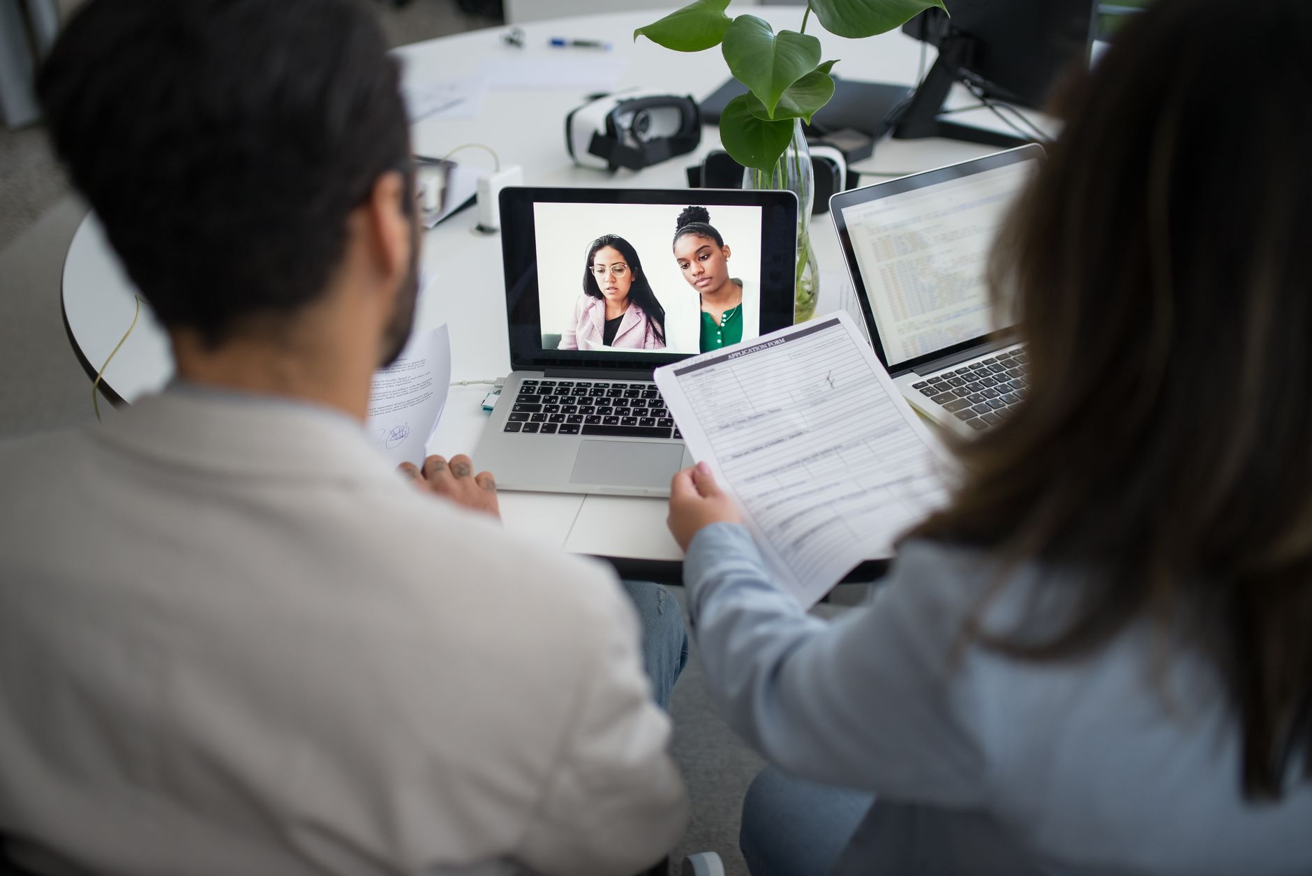 Profissional participando de uma entrevista remota diante de um laptop em casa