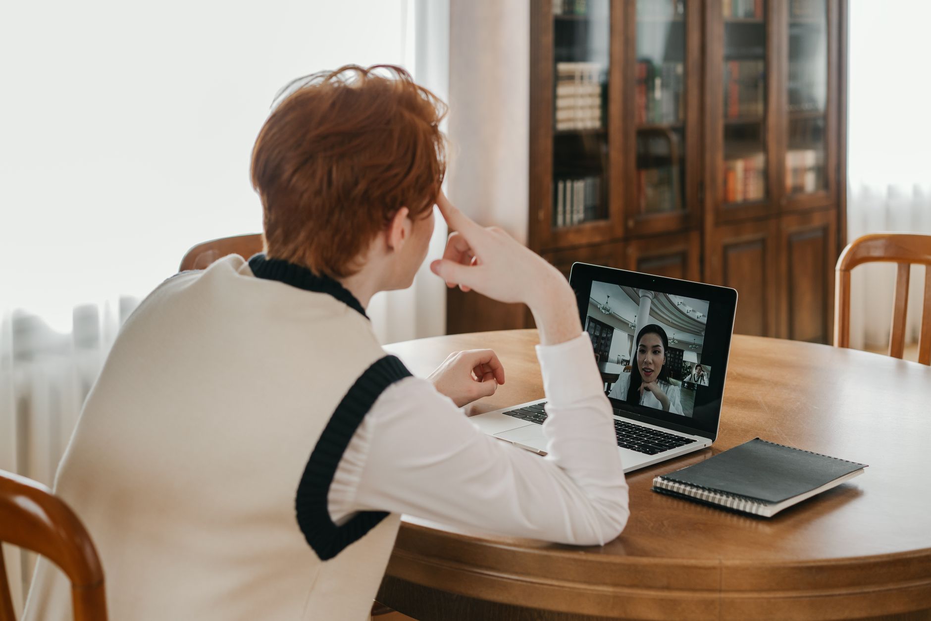Pessoa em home office participando de uma reunião de feedback por videochamada no notebook