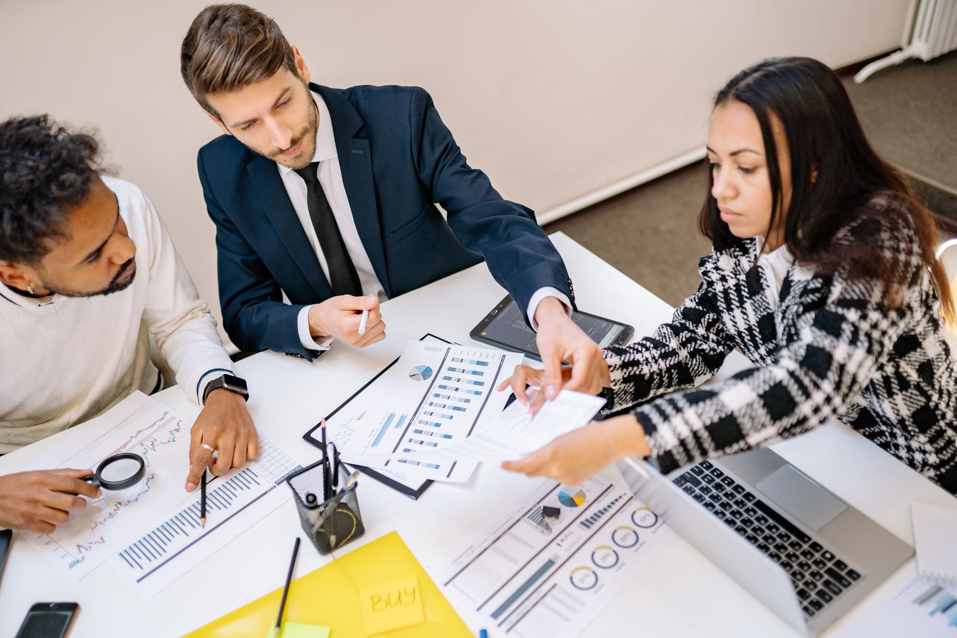 Vagas remotas na área de dados: como encontrar Business professionals engaging in a collaborative meeting with charts and documents.