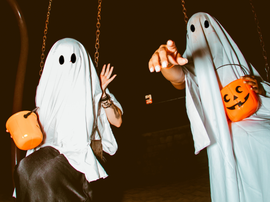 People in Ghost Costume on Swings