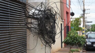 RISCO: Fios amarrados em poste em trecho da rua 4 entre avs. 27 e 29 Empresa afirma que notifica operadoras sobre cabos e fios de telefonia