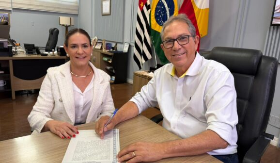 Flávia, representante da JBS, e o prefeito Odair durante a assinatura (Foto: Divulgação)