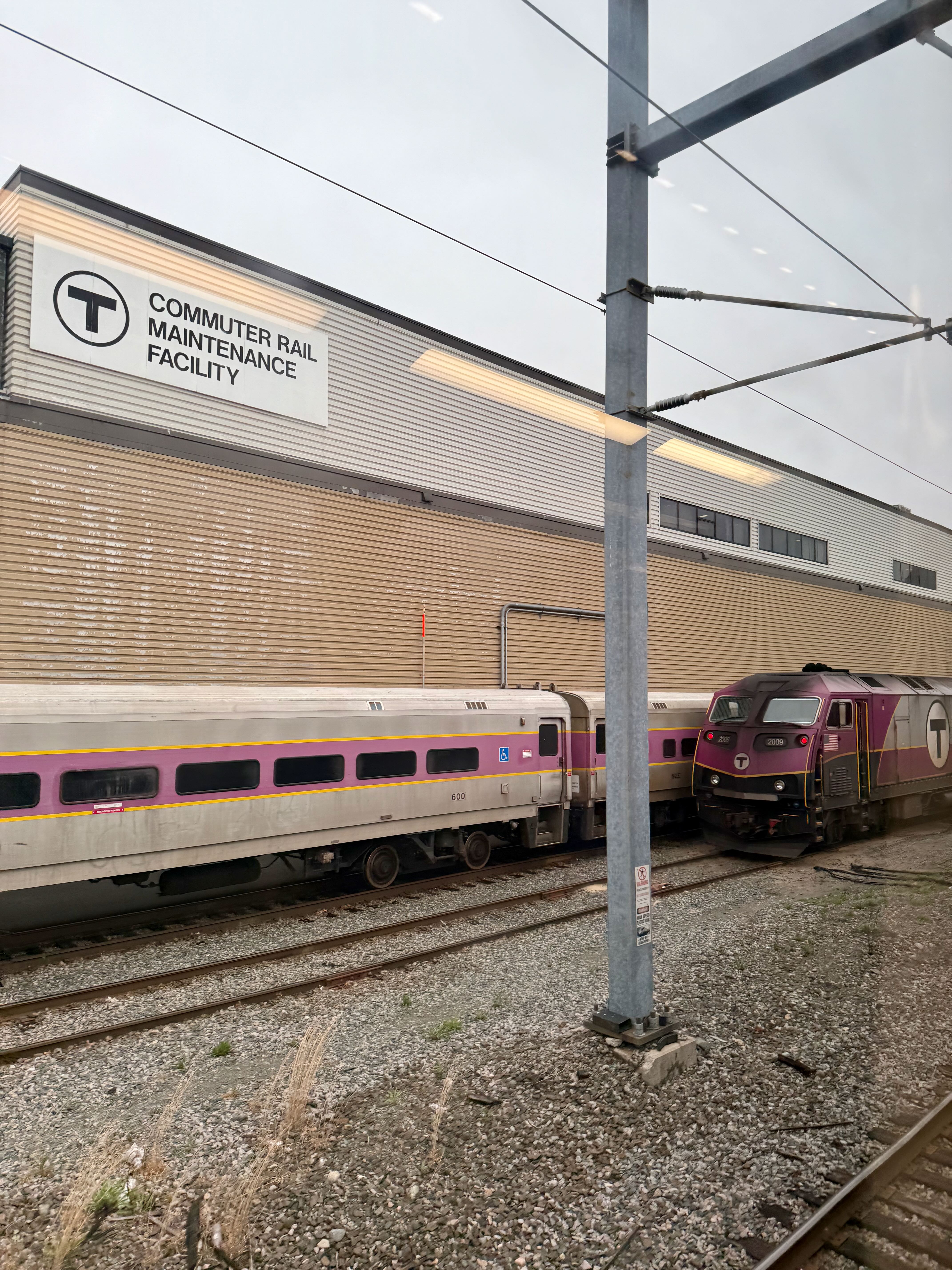 A commuter rail maintenance facility with two tracks of trains parked in front