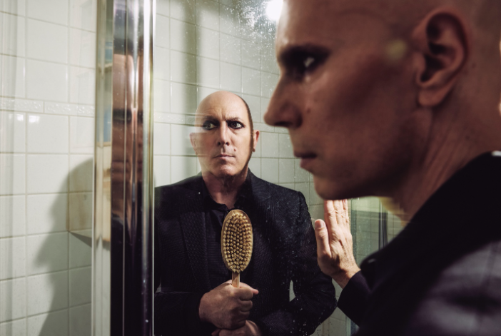 A person looking at himself in the mirror

Description automatically generated