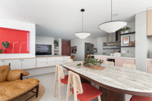 Executado pela arquiteta Duda Senna, o projeto integra sala de TV, sala de jantar, cozinha e gourmet em uma composição contínua com a península que agrega atividades de preparo e convivência | Fotos: Gisele Rampazzo