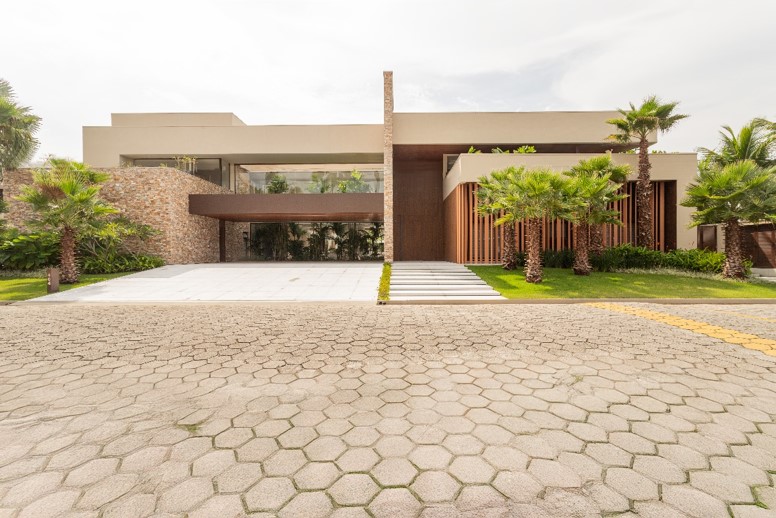 A residência possui dois pavimentos e a arquiteta Patricia Penna explorou sua altura também na fachada: o pé-direito duplo da caixa da escada ganha destaque com o paisagismo ao fundo da garagem, que também auxilia na maior privacidade | Projeto: Patricia Penna Arquitetura & Design| Foto: Leandro Moraes