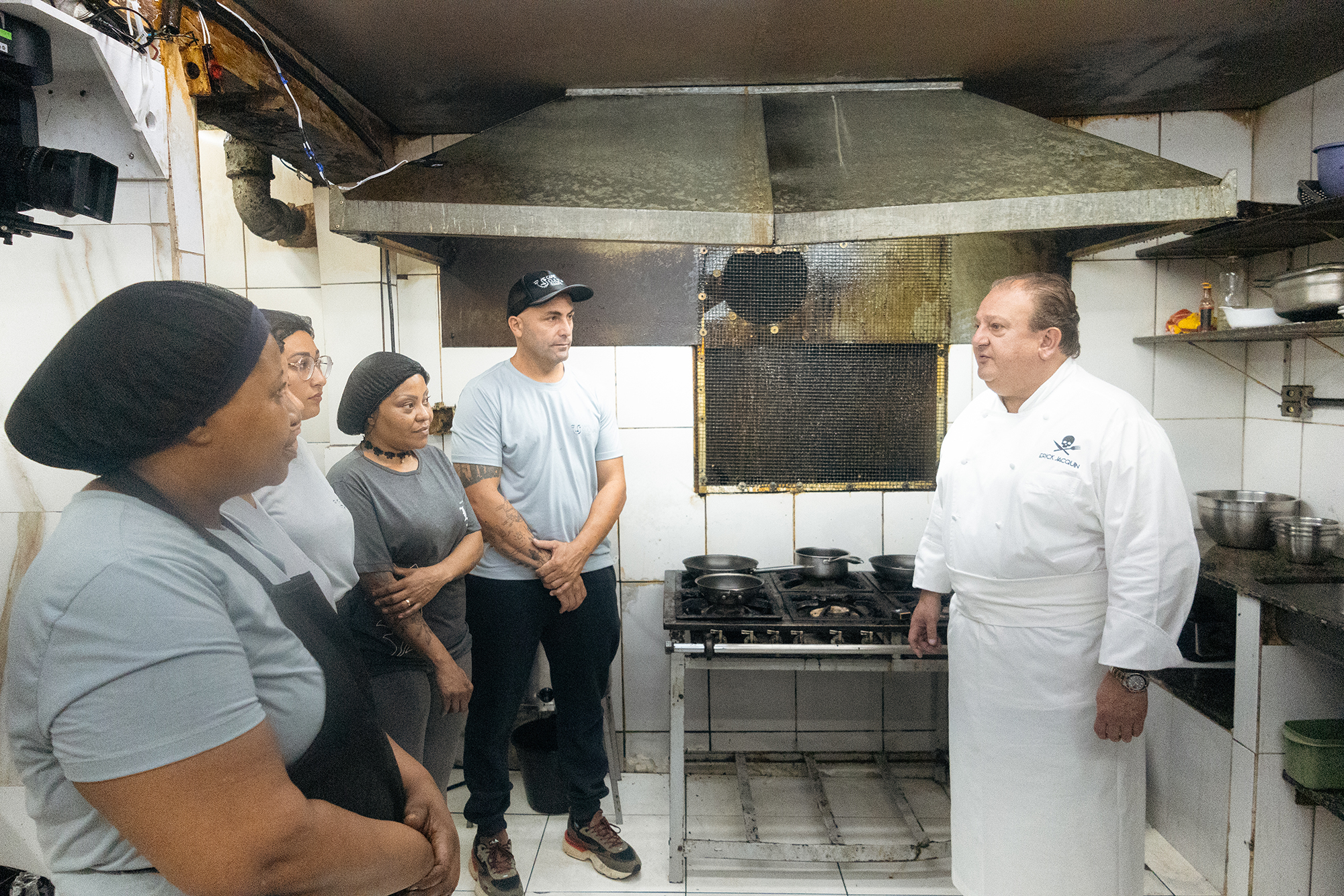 Erick Jacquin conversa com a equipe do Café Cultura Bar em uma cozinha com condições precárias.